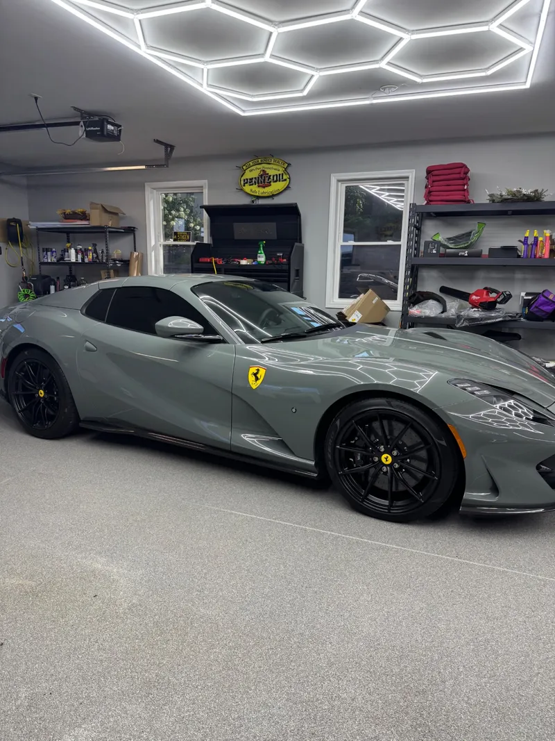 Grey Ferrari 812 Superfast under hex bay lighting after a ceramic window tint install.